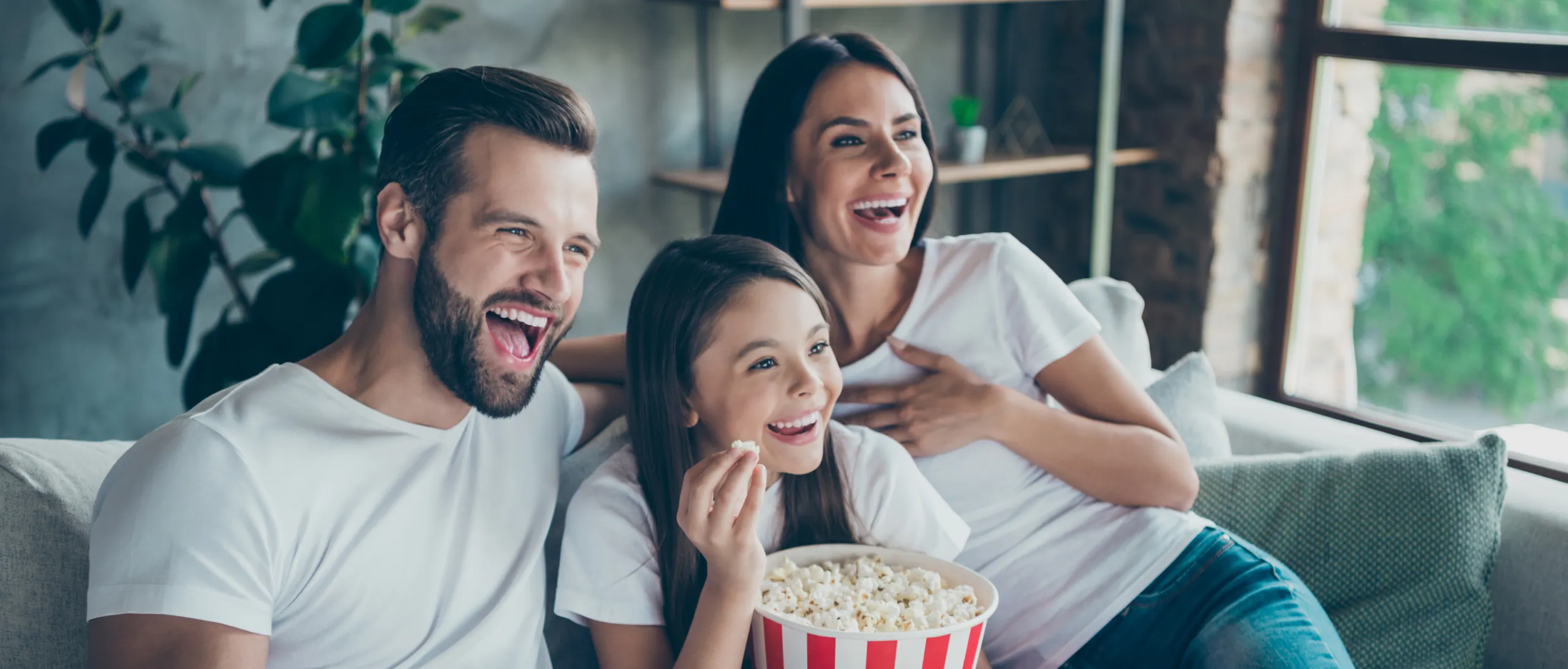 Familj ser på tv och äter popcorn